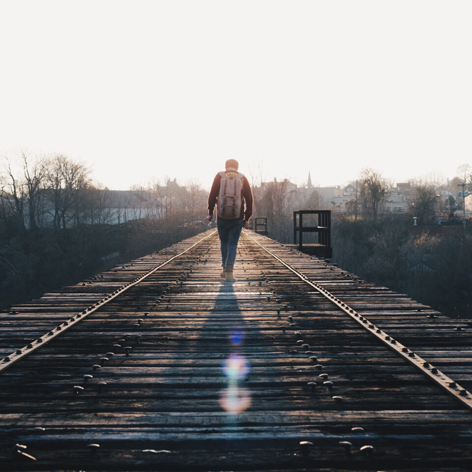 Man Walking on a Wooden Bridge