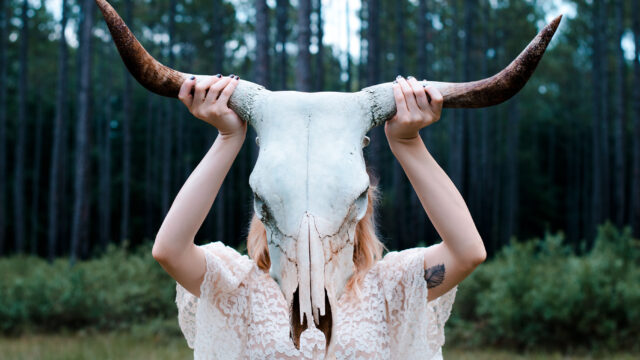 Blond Girl Holding Skull in the Forest